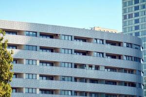 ny lägenhet byggnad med glas balkonger. modern arkitektur hus förbi de hav. stor glas på de Fasad av de byggnad. foto