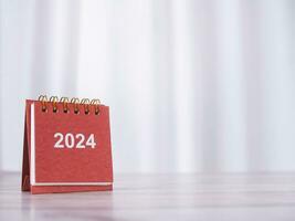 stänga upp 2024 skrivbord kalender på de tabell med kopia Plats. upplösning, mål, handling, planera, och klara av till Framgång företag. foto