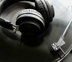 svart hörlurar på vinyl skiva av klassisk skivspelare detaljerad topp se foto