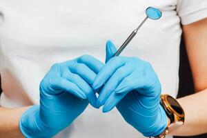 dental spegel för de oral hålighet i de händer av en kirurg. foto