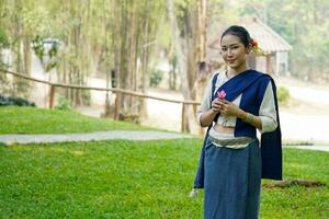 porträtt av skön lantlig thai kvinna ha på sig thai nordlig traditionell klänning verkande för Foto skjuta i offentlig parkera