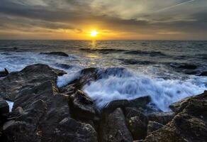 stormig hav med de färgrik soluppgång himmel på de klippig kustlinje av de svart hav foto