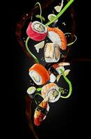 blandad sushi med garneringar svävande i luft på svart bakgrund foto
