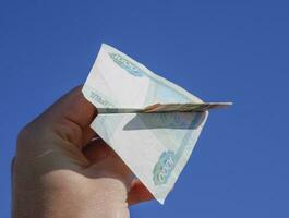 valörer av ryska pengar, vikta i de flygplan mot t foto
