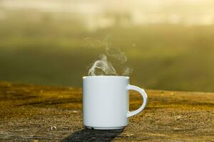 vit kaffe kopp med solnedgång tid. foto