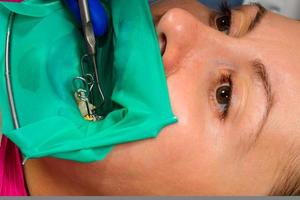 läkaren utför sterilt arbete med tandrestaurering. foto