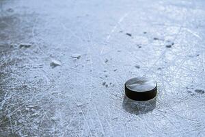 svart hockey puck lögner på is på stadion foto