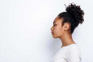 på en vit bakgrund står en afroamerikansk tjej i profil foto