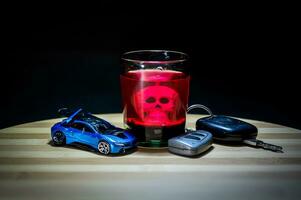 alkoholhaltig dryck och bil nycklar under fläck ljus. foto