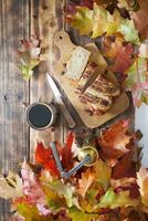 banan kaka på de trä- tabell med orange höst löv, koppar kaffe kvarn foto