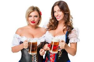 två skön blond och brunett flickor av oktoberfest öl ölkrus foto