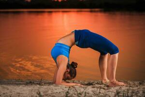 yoga på solnedgång på de strand. foto