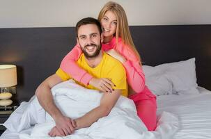 ung härlig par ha roligt i en säng foto