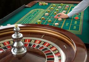 roulett och pålar av hasardspel pommes frites på en grön tabell. foto