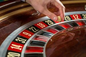 roulett hjul och croupier hand med vit boll i kasino foto