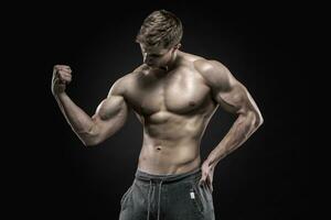 fantastisk muskulös man som visar perfekt magmuskler, axlar, biceps, triceps, bröst foto