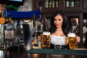 oktoberfest. brunett kvinna innehav öl muggar i bar foto