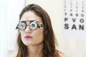 vacker kvinna testar nya hjälplinser med phoropter foto