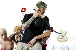 tatuerade rap sångare Framställ i studio med en kvinna dummy foto