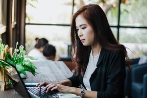 asiatiska affärskvinnor som använder anteckningsbok för arbete foto