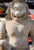 en staty av en demon med en leende på dess ansikte foto