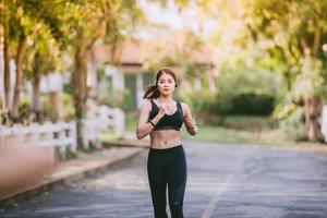 asiatiska kvinnor springer och joggar under utomhus på vägen i parken