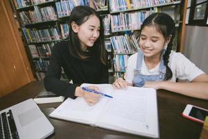 asiatiska studenter som läser böcker i biblioteket. foto