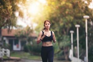 löpande kvinna. kvinnlig löpare joggar under utomhus på vägen. ung blandad tjej joggar foto