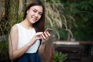 asiatiska affärsmän och kvinnor använder mobiltelefon och touch smartphone för kommunikation och kontroll av affärsmän i kontorsbakgrund foto