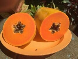 de papaya frukt på en trä- tabell och en rustik tyg på de bakgrund foto