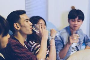 asiatisk grupp vänner som har fest med alkoholhaltiga öldrycker och ungdomar som njuter i en bar som rostar cocktails. mjuk fokus foto