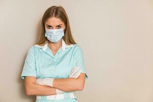 porträtt av arg sjuksköterska med skyddande mask och handskar. foto