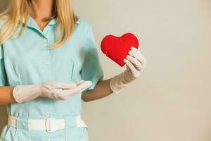 bild av medicinsk sjuksköterska innehav röd hjärta. foto