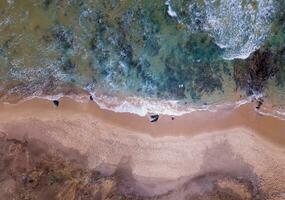 antenn topp se av sandig strand med fantastisk vågor. foto