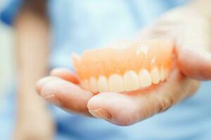 läkare innehav tänder tandprotes i hand för tandläkare studerar handla om tandvård. foto