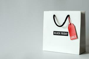 handla väska med ord på röd pris märka och ord svart fredag på vit bakgrund för svart fredag handla försäljning begrepp. foto