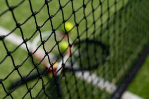ett tennisracket och en ny tennisboll på en nymålad tennisbana foto