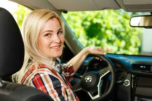 självsäker och skön. attraktiv ung kvinna i tillfällig ha på sig körning en bil foto