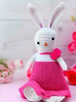 ai genererad stickat kanin i rosa klänning. st. hjärtans dag dekor. stickat leksak, amigurumi. valentines dag hälsning kort ai genererad foto