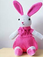 ai genererad stickat kanin i rosa klänning. st. hjärtans dag dekor. stickat leksak, amigurumi. valentines dag hälsning kort ai genererad foto