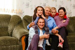 mormor och barnbarn Sammanträde tillsammans på soffa i levande rum foto