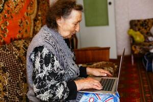 teknologi, gammal ålder och människor begrepp - Lycklig senior kvinna har video ring upp på Hem i kväll foto