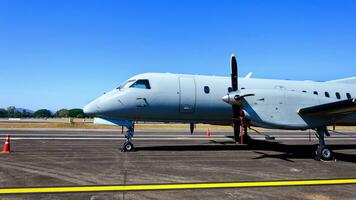 privat exklusiv små jet flygplan parkerad på asfalten av flygplats, blå himmel område, privat jet på de landningsbanan. foto