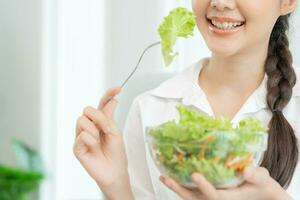 friska mat. skön kvinna flicka leende njut av äta färsk vegetabiliska sallad på frukost hälsa. Lycklig asiatisk kvinna Bra känsla. bantning, detox, diet, tappa bort vikt, rena äta, vegetarian, dietist foto