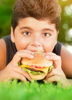 hungrig pojke äter burger foto