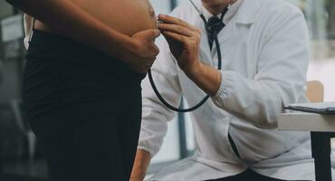 kvinna läkare är kontroll gravid kvinna med stetoskop. begrepp omtänksam för gravid kvinna foto