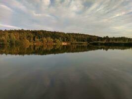 sjö och skog i solnedgång, pittoresk tapet foto