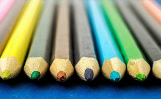 en rad av färgad pennor på en blå yta foto
