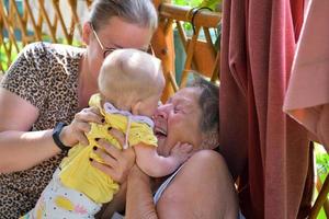 mormor jublar och ler från barnflickan och de har familjeglädje foto