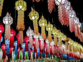 färgrik panorama och perspektiv se av thai lanna stil lyktor till hänga i främre av de tempel på natt tid i loy kratong festival. foto